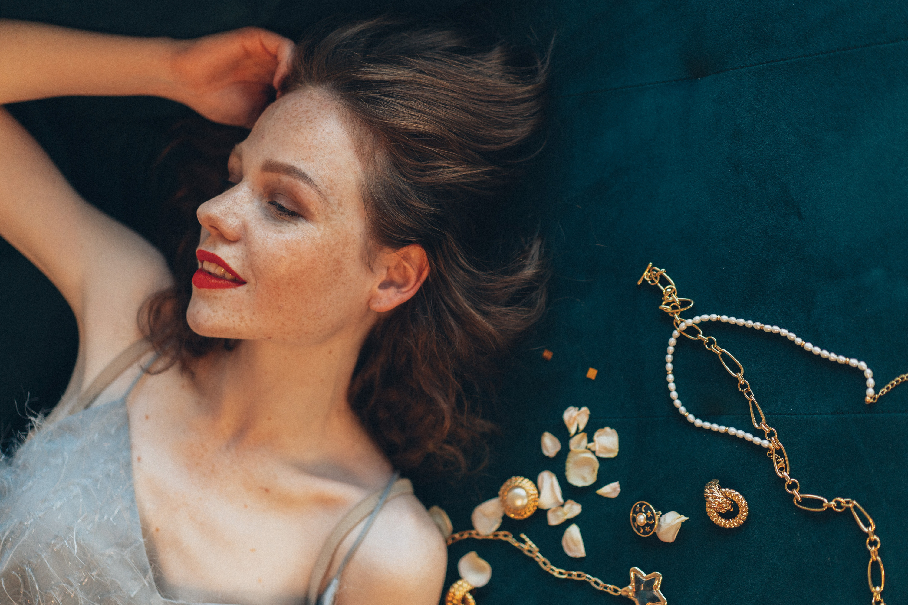 Woman with Jewelries Lying on Green Surface